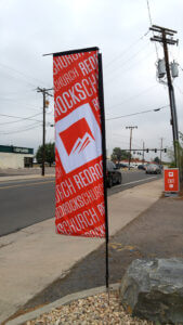 Red Rocks Church custom flag displaying the church logo, symbolizing faith and community in Denver, Colorado.