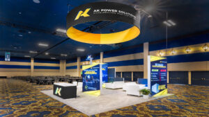 Custom rental booth by AK Power Solutions featuring light boxes, holograms, and a sleek custom counter.