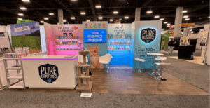 Pure Cravings 10x20 booth with sleek design elements, vibrant colors, and organized product displays to attract visitors.
