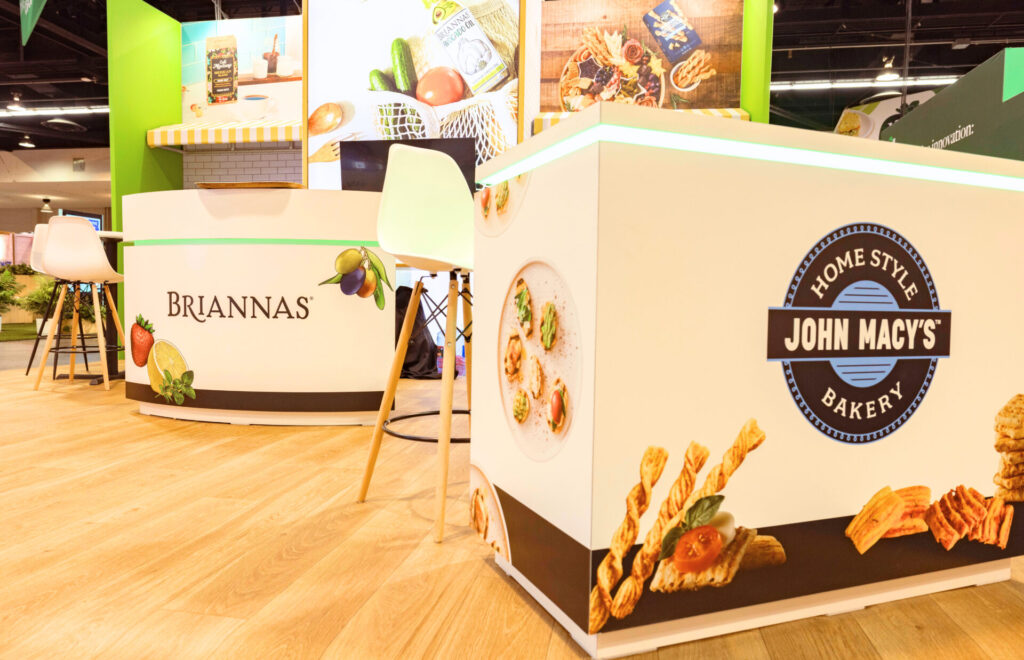 Del Sol Food Company trade show booth rental at Expo West with branded counters, backlit tower and product displays